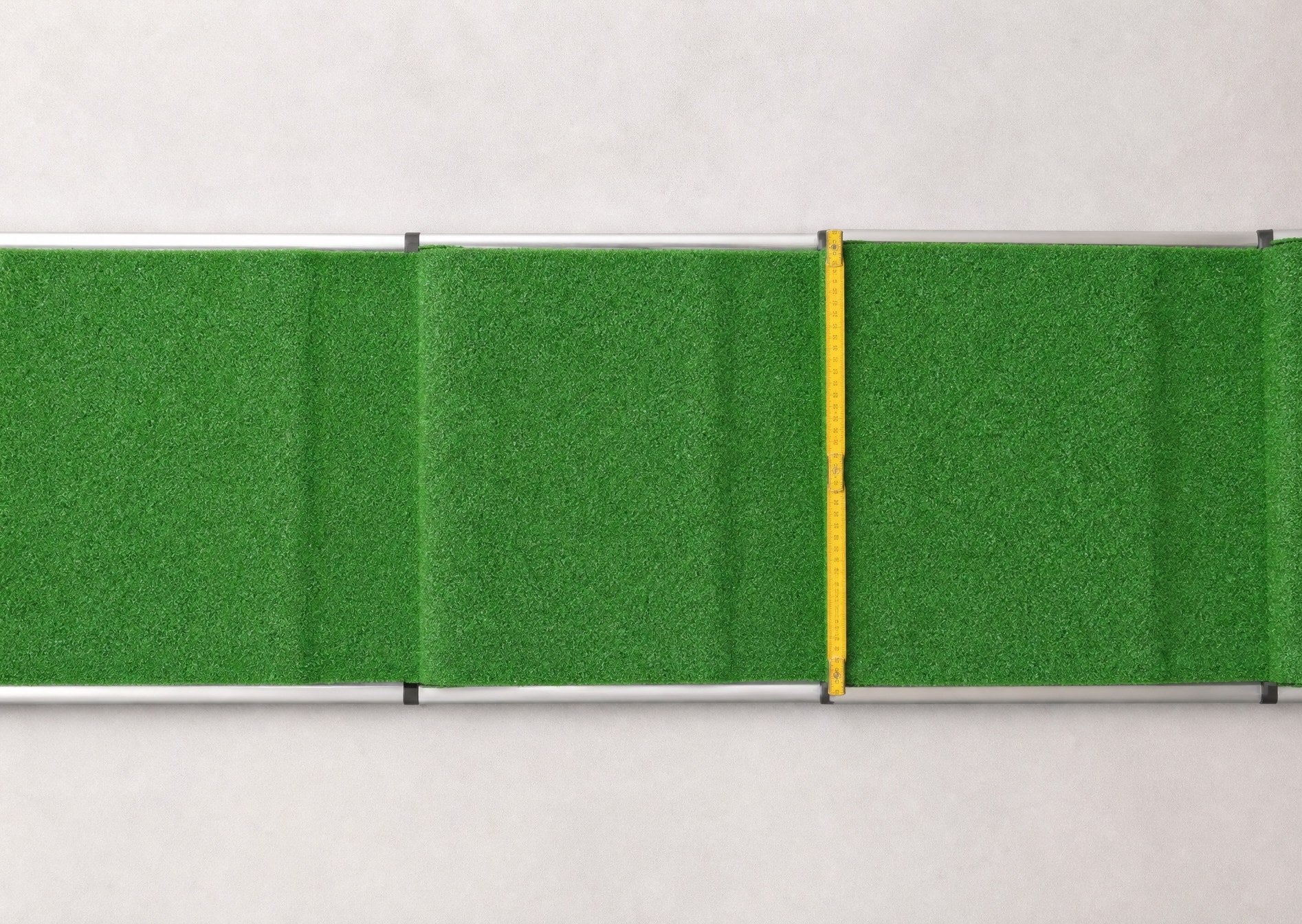 Kunstrasen der Lauffläche mit Maßband